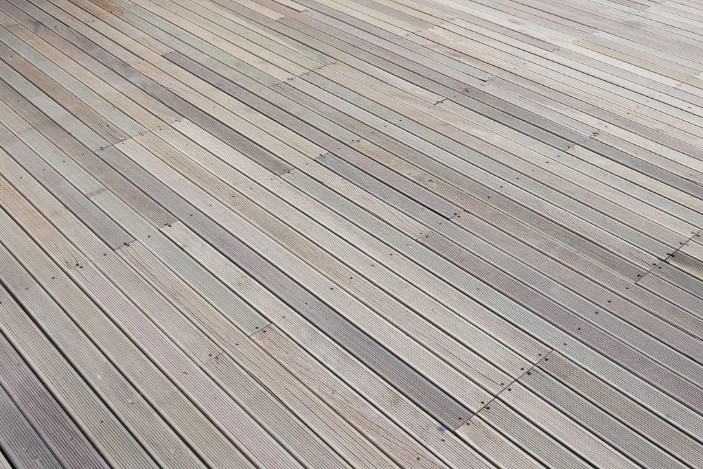 Light gray wooden planks installed in a diagonal pattern, showing natural grain and texture in a outdoor decking style.